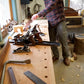 Student using hand planes on a Roubo workbench in a woodworking class