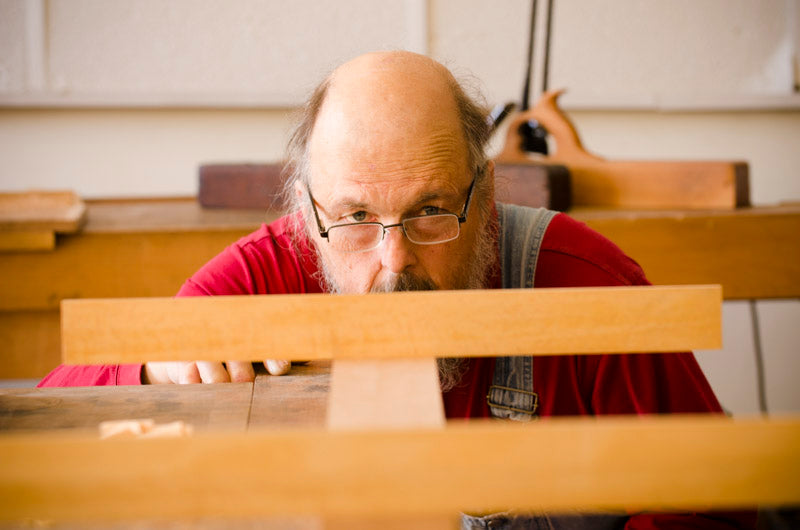 Bill Anderson using winding sticks to ensure the flatness of his new wooden hand plane