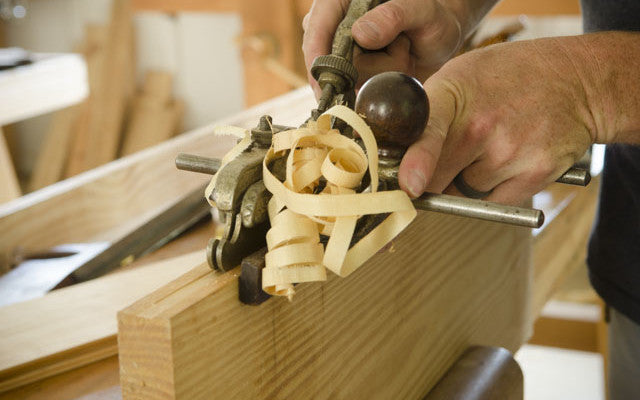 Bill Anderson using a plow plane to cut a groove with shavings