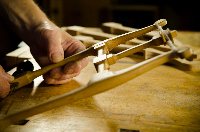 Bill Anderson holding a recreated Howarth Bowsaw on a woodworking bench