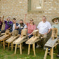 Students in a woodworking class sitting on shaving horses that they just built