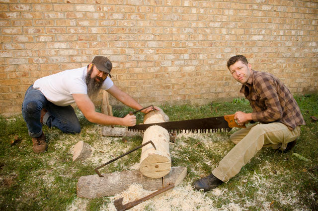 Willie and Ervin Ellis using a crosscut saw to cut a log for a woodworking class on making a shave horse