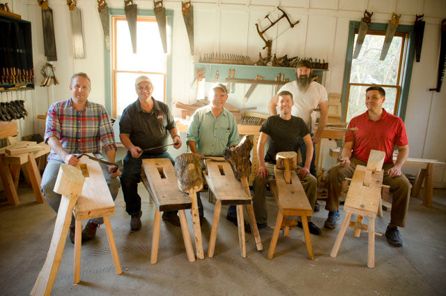 Students in a woodworking class sitting on shave horses that they just built