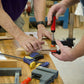 Woodworkers in a hand tool woodworking calss gluing up a wooden try square with wood clamps