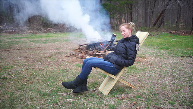 Beautiful woman sitting next to a campfire in a Viking camp chair
