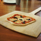wooden pizza peel with homemade pizza