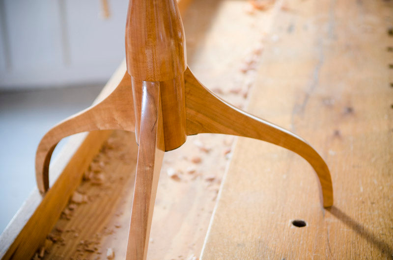 Feet of a Hancock shaker candle stand sitting on a Moravian Workbench