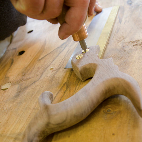 Student tightening a brass saw nut while making a dovetail saw in a hand tool woodworking class 