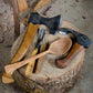 Intro to Green Woodworking class with axe, hook knife, adze, wooden spoon on stump