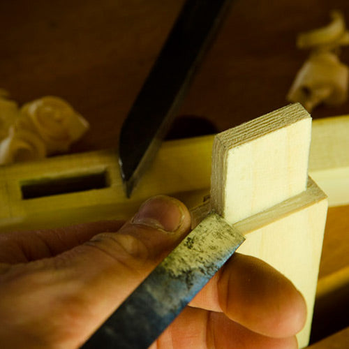Joshua Farnsworth holding a wood chisel cutting a mortise and tenon joint