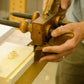Students using a wooden plow plane at the introduction to hand tool woodworking class 