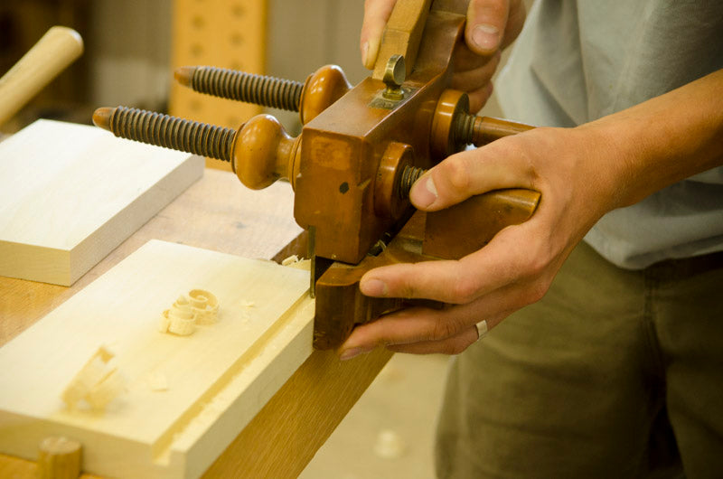 Students using a wooden plow plane at the introduction to hand tool woodworking class 