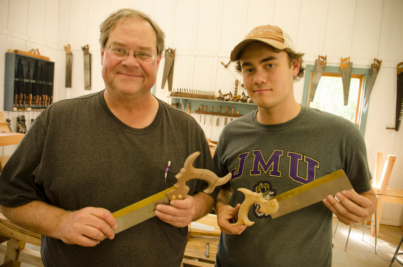 Father and son with their own dovetail saw made in a hand tool woodworking class 