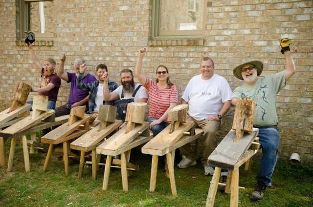 Students in a woodworking class sitting on shaving horses that they just built