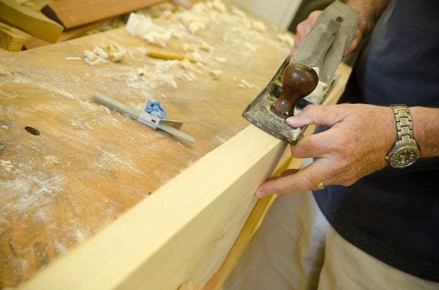 Man using a Stanley jointer plane to joint a board at a hand tool woodworking class
