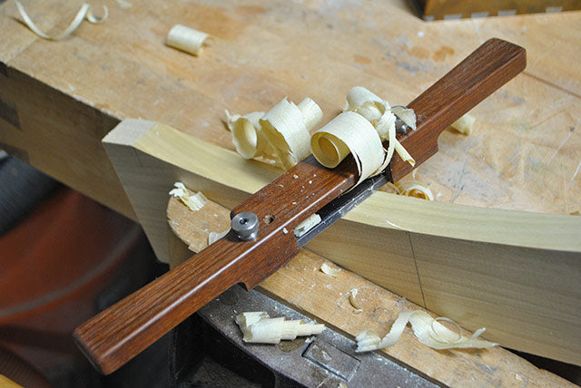 Tom Calisto using a wooden spokeshave that he makes in a woodworking class
