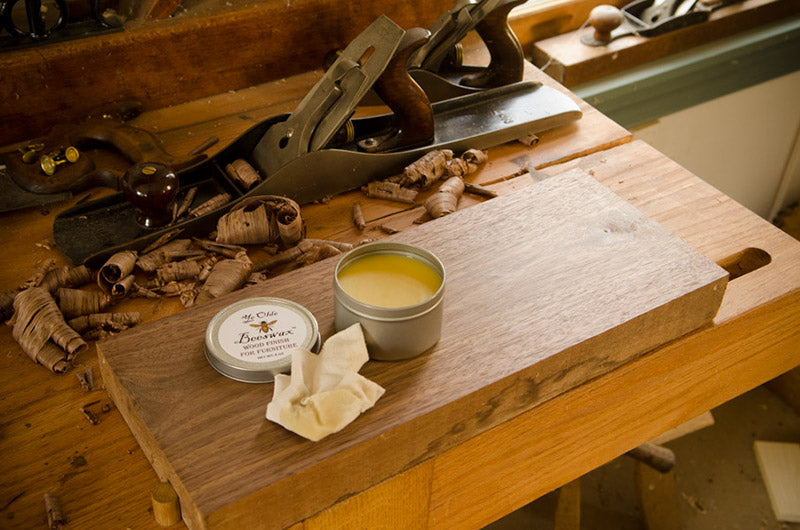 Applying Ye Olde Beeswax Wood Finish for Furniture on a Walnut board with Stanley hand plane in the background 